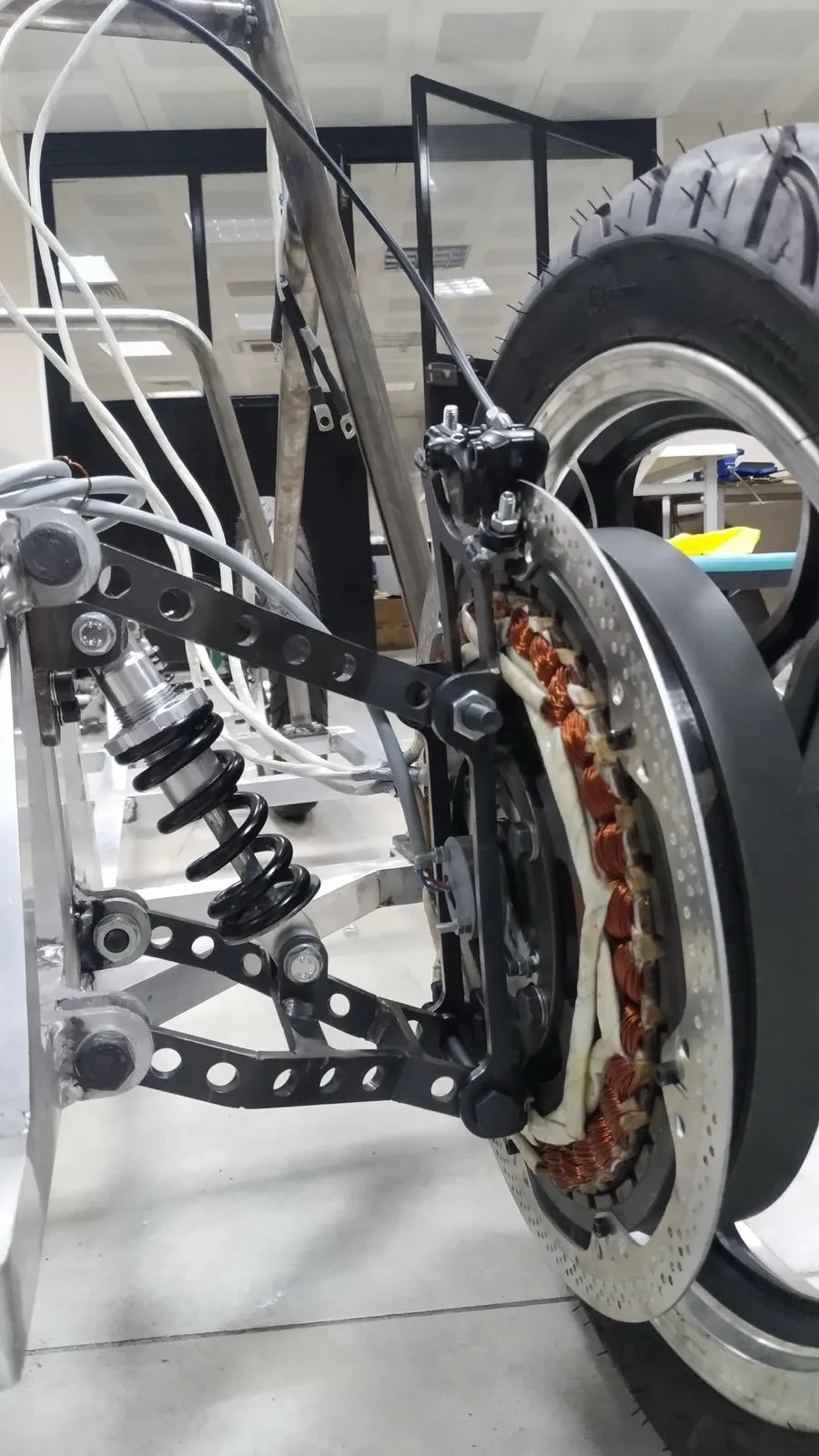 Motor tekerlek göbeğine takılı; sargılar fren diskinin arkasında görünüyor